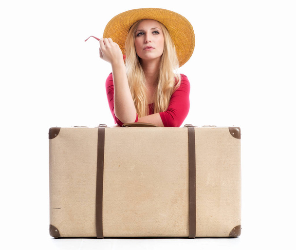 an arrogant blond woman sitting behind a suitcase - Foto, immagini