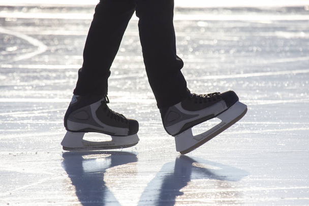 Legs of a man skating on an ice rink. Hobbies and sports. Vacati - Foto, imagen