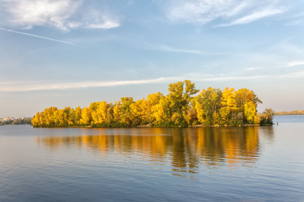 Herbstinsel und ihr Spiegelbild im blauen Wasser - Foto, Bild