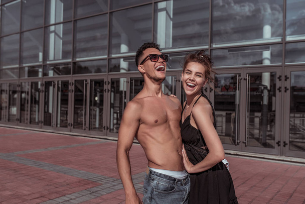 Happy cheerful couple man girl laughing, dancers trained tanned torso, sport dancing, summer city, hip hop, style dancing, youth lifestyle. Street urban fitness. - Photo, image