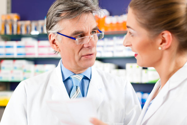 pharmacist in pharmacy with a drug in hand for advice - Foto, imagen