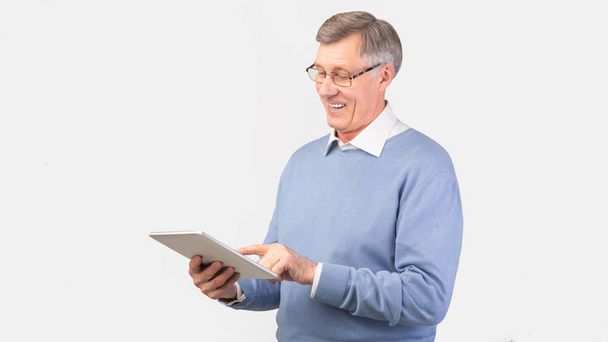 Hombre mayor satisfecho usando Tablet Computer sobre fondo gris, Panorama
 - Foto, Imagen