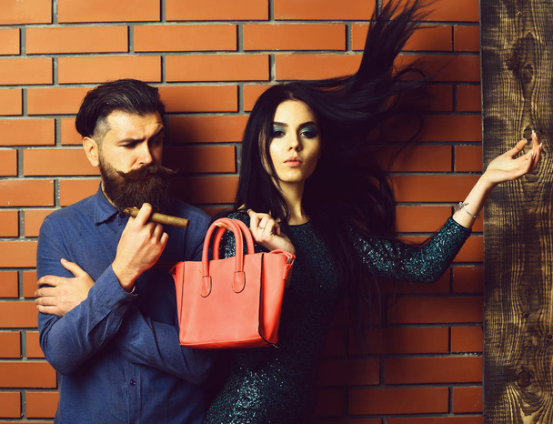 bearded man and pretty sexy woman with bag and cigar - Foto, Imagen