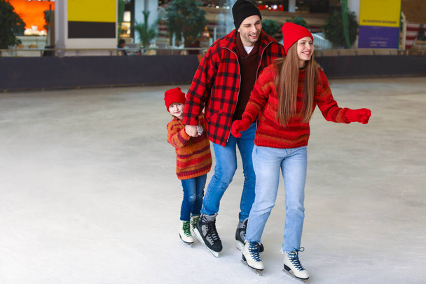 Familia feliz en pista de patinaje
 - Foto, imagen