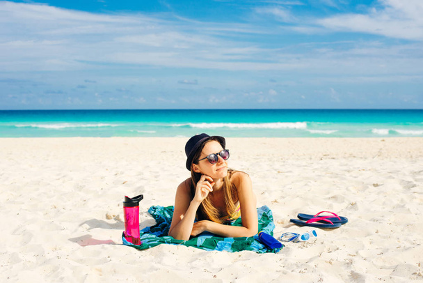 κορίτσι με γυαλιά ηλίου κάνει ηλιοθεραπεία στην παραλία στο Κανκούν του Μεξικού σε μια ηλιόλουστη μέρα - Φωτογραφία, εικόνα