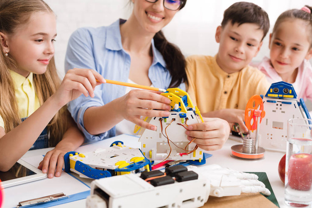 Science school. Teacher with pupils building robots - Photo, Image