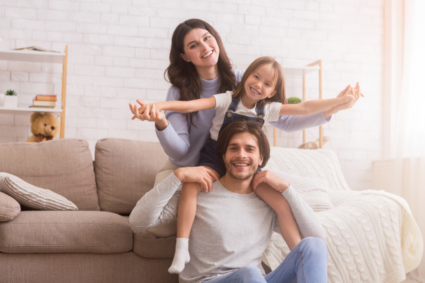 Boldog család szórakozás és pózol a nappaliban otthon - Fotó, kép