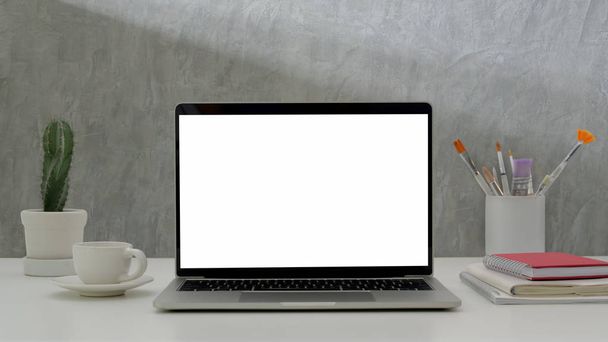 Close up άποψη του σύγχρονου καλλιτέχνη στο χώρο εργασίας με mock up laptop, ζωγραφική βούρτσα και προμήθειες γραφείου  - Φωτογραφία, εικόνα