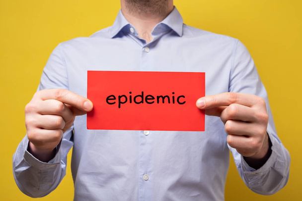 Człowiek trzymający czerwony sztandar ze słowem epidemia. Koncepcja ochrony przed pandemią wirusa - Zdjęcie, obraz