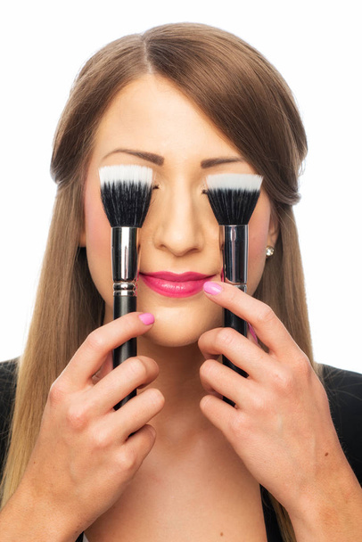 a woman covers her eyes with a make-up brush - Φωτογραφία, εικόνα
