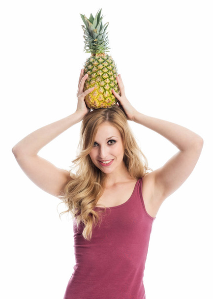 a woman holding a pineapple - Фото, изображение