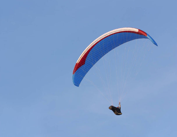 El parapente vuela contra el cielo azul
 - Foto, Imagen