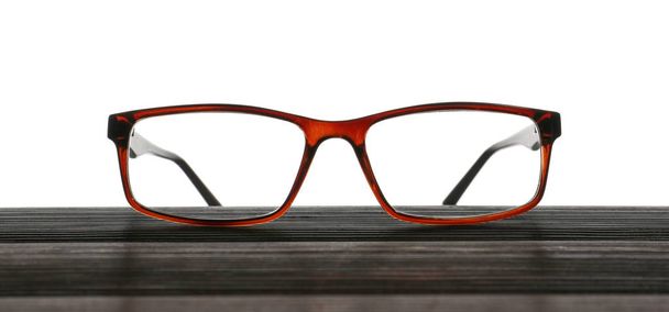 Stylish eyeglasses on wooden table against white background - Photo, Image