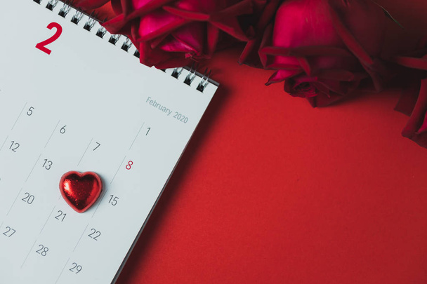Fehér könyv naptár és vörös rózsa piros háttér - Fotó, kép
