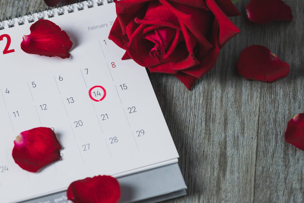 Calendario de papel blanco y rosas rojas
 - Foto, Imagen