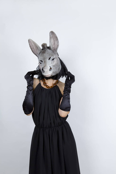 Woman wearing a donkey mask with an evening dress and evening gloves - Foto, imagen