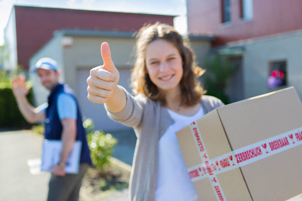 Young attractive woman happy to receive parcel - Foto, Bild