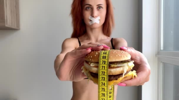 ダイエット。ジャンクフードを食べるのを妨げる若い女性。健康的な食事の概念 - 映像、動画