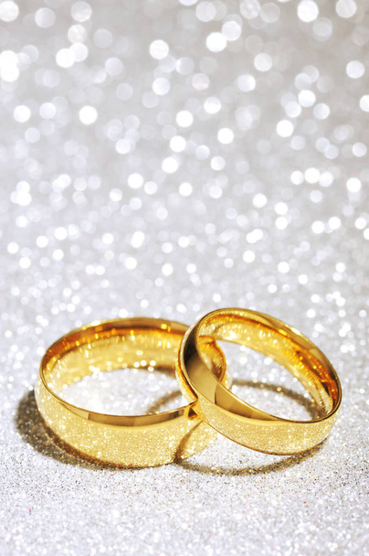 two golden rings on white glitter background\n - Foto, Imagem