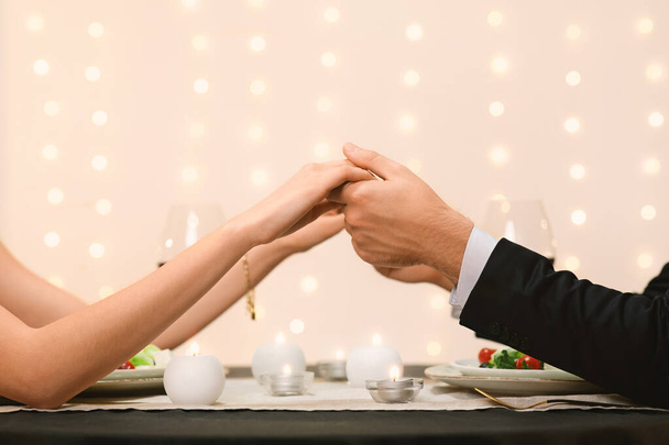 認識できないカップルが提供するレストランのテーブルの上に手を握る背景 - 写真・画像