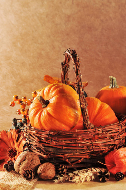 thanksgiving - different pumpkins in rattan basket against brown background candlelight\n - Photo, Image