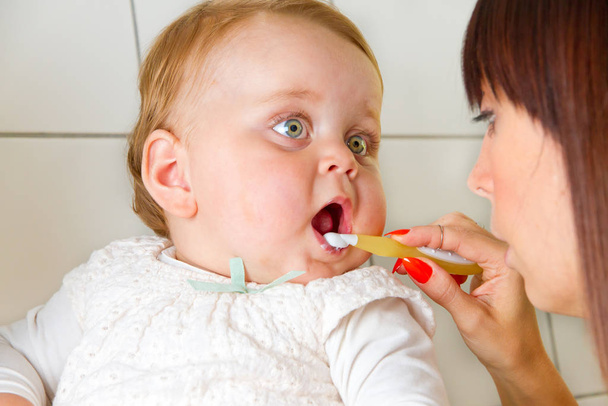 mama brushing teeth of her baby - Zdjęcie, obraz