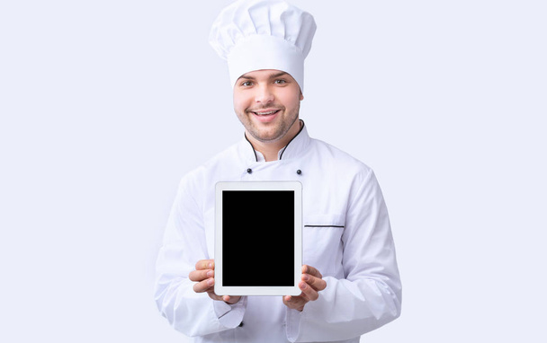 Chef Guy mostrando la pantalla de la tableta de pie sobre fondo blanco, burla
 - Foto, Imagen
