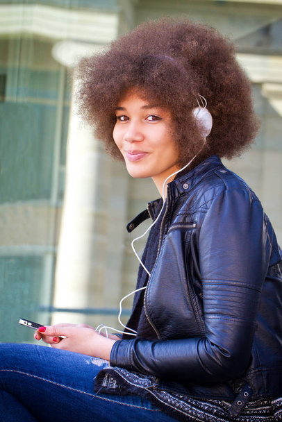 Νεαρή γυναίκα με ακουστικά - Φωτογραφία, εικόνα