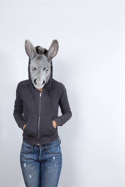 Woman wearing a donkey mask and miming hip hop culture.She is wearing a hoody and a jean with holes - Фото, зображення