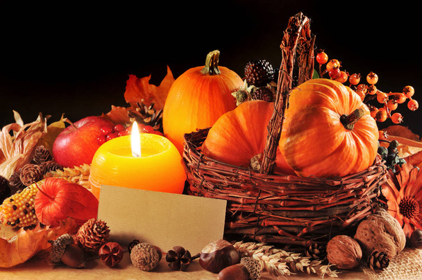 thanksgiving - various squashes,nuts,corn and apple in rattan basket with candlelight and copy space\n - Photo, Image