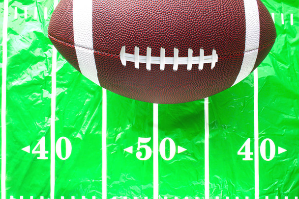 Voetbal op een plastic gemonteerde Amerikaanse voetbal veld tafelkleed - Foto, afbeelding