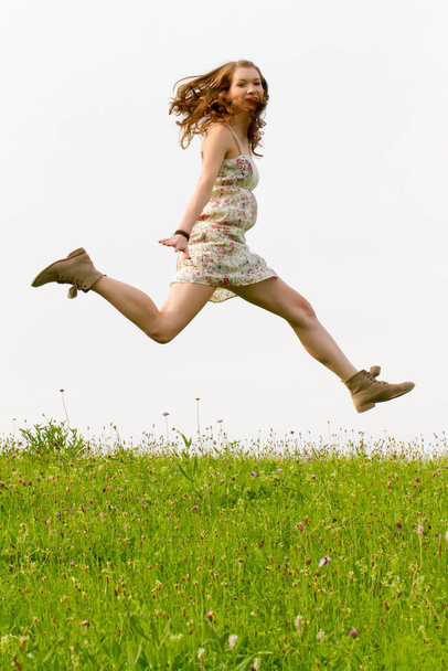 young woman jumping in the field - Fotoğraf, Görsel