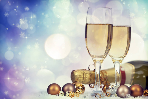 Glasses with champagne and Christmas decoration on winter background - 写真・画像