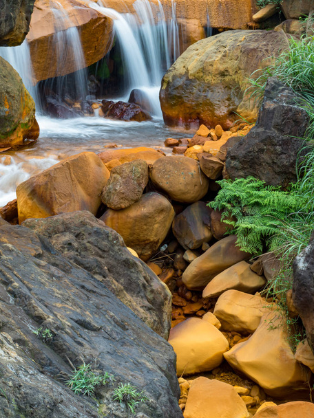 Απαλό τρεχούμενο νερό που πέφτει πάνω σε βράχια  - Φωτογραφία, εικόνα