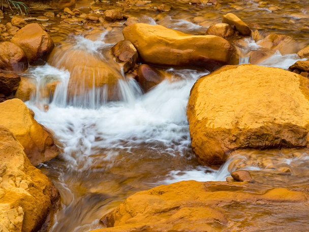 Απαλό τρεχούμενο νερό που πέφτει πάνω σε βράχια  - Φωτογραφία, εικόνα