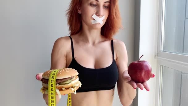 Dieta. Mujer joven impidiéndole comer comida chatarra. Concepto de alimentación saludable
 - Metraje, vídeo