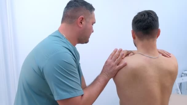 Doctor chiropractor treats patient shoulder in clinic on rehabilitation therapy. - Imágenes, Vídeo