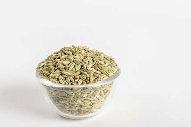 Glass bowl with fennel seeds on a white background - Fotó, kép