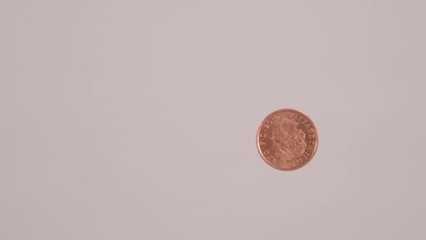 A worm's eye view of someone sliding a UK penny across a glass table - Filmmaterial, Video