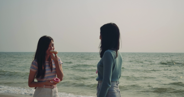 Vrouwen vrienden genieten van het leven donuts zoete heerlijke ontspannen en vrijheid zomervakantie op het strand, Aantrekkelijk samen van Aziatische vrouwelijke reiziger mensen levensstijl. 4k Uhd Filmbeelden. - Video