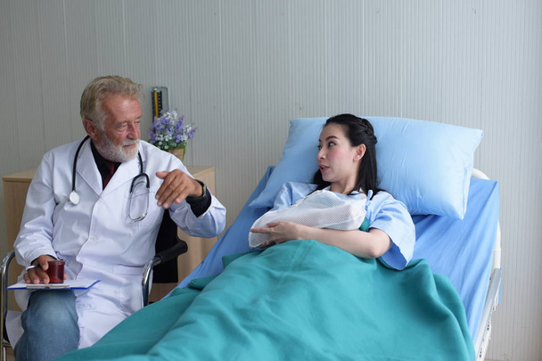 The doctor is taking care of the patient and checking the body and talking to the patient at the hospital - Photo, image