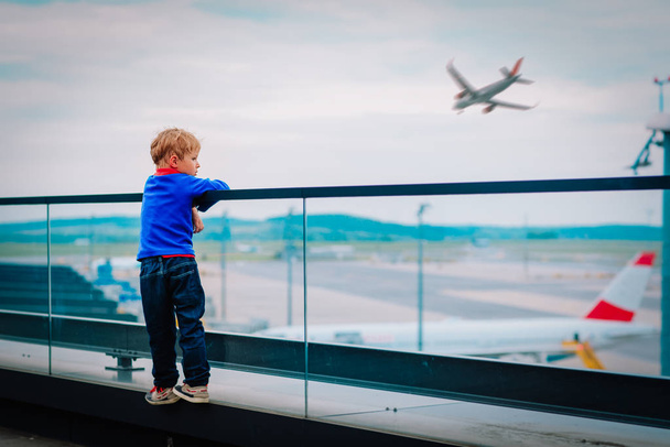 słodkie mały chłopiec patrząc na samoloty na lotnisku - Zdjęcie, obraz