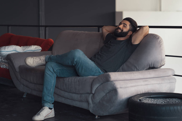 Jeune homme assis relaxant sur le canapé
 - Photo, image