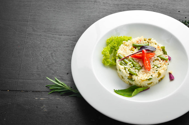 Risotto. Rice with vegetables in a plate. Top view. Free space for your text. - Фото, изображение