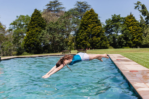 Girl diving home swimming pool summer playtime - Фото, изображение