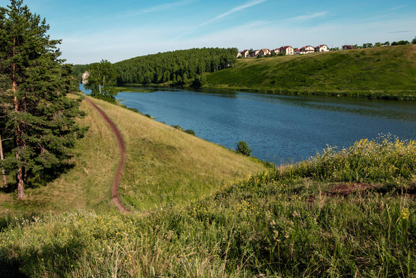 landscape hilly terrain river flows on one side a field - Фото, зображення