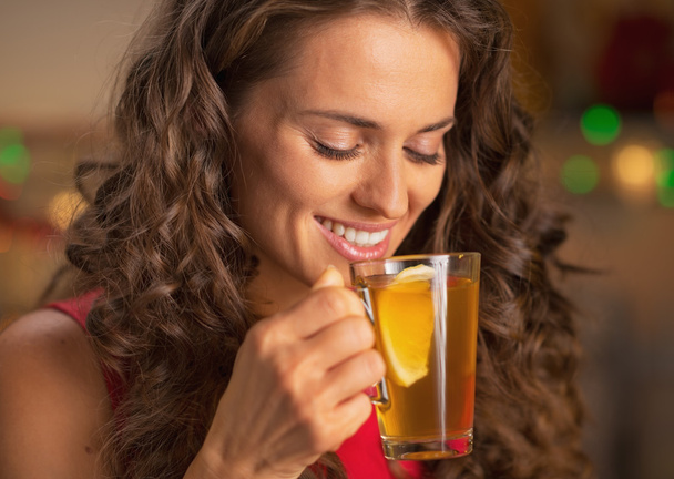 Happy young woman drinking ginger tea with lemon - Photo, image