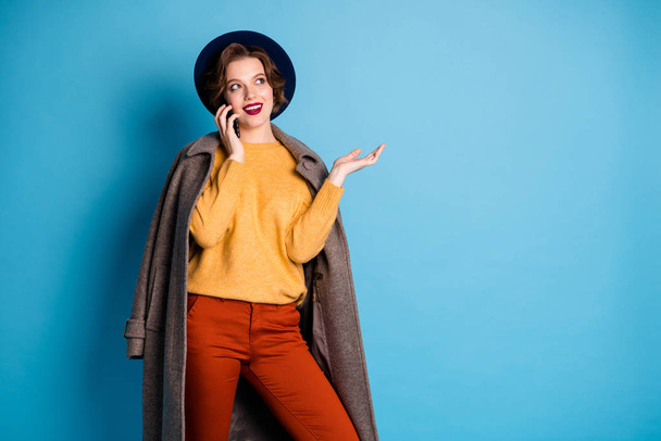 Photo of pretty lady walk street traveler speaking telephone with friends telling address to go wear casual long grey coat pullover trousers hat shoes isolated blue color background - Foto, immagini