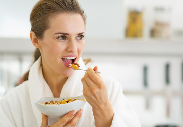 Young housewife in bathrobe having healthy breakfast in kitchen - Foto, immagini
