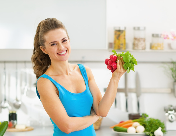 Happy young woman holding bunch of radishes - Фото, зображення